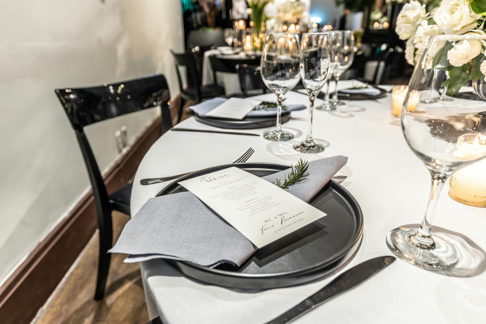 Elegant table setting with a menu and wine glasses, perfect for dinner events.